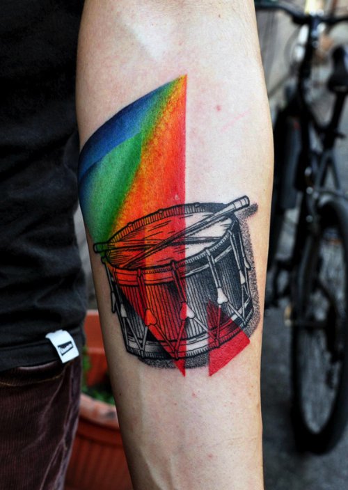Marcin Aleksander Surowiec é o nome do tatuador polonês, mestre do que muito gente chamaria do estilo neo tradicional de tatuagem. Suas referências visuais vem da música, de desenhos animados antigos, animais, plantas e tatuagens old school. No seu trabalho você pode observar figuras humanas e elementos abstratos se somando a uma dezena de cores. Um visual que fica bem interessante