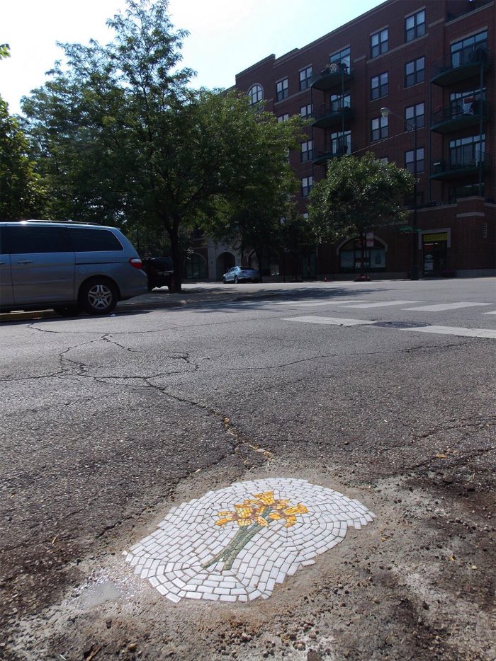Você não deve ter pensado nisso mas Chicago parece sofrer com um problema de buracos pelas ruas da mesma forma que algumas cidades no Brasil. É, esse problema não é localizado no seu bairro e, pelo menos, algumas pessoas tomam uma iniciativa diferente em outros lugares. Ainda bem. Foi assim que Jim Bachor começou a sua crítica a falta de infra estrutura da cidade de Chicago ao começar a cobrir os buracos da cidade com mosaicos. Sim, mosaicos de azulejos formando pequenos desenhos e cobrindo buracos nas ruas da cidade. Por que ninguém pensou em fazer isso antes? 