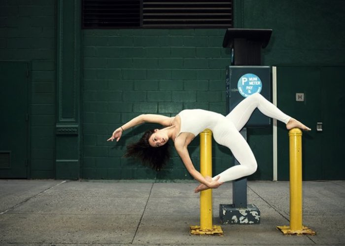 Anja Humljan é uma artista, arquiteta, dançarina e professora de yoga. Além disso tudo, ela resolveu criar o estranho projeto chamado de Yoga Urbano (Urban Yoga em inglês, claro). Nesse projeto, ela convida as pessoas a se juntar e render seu corpo ao cheiro, som, toque e visão em função de experimentar como a cidade realmente é.