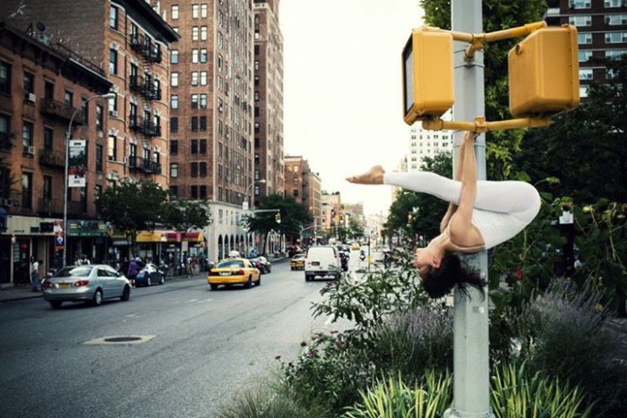 Anja Humljan é uma artista, arquiteta, dançarina e professora de yoga. Além disso tudo, ela resolveu criar o estranho projeto chamado de Yoga Urbano (Urban Yoga em inglês, claro). Nesse projeto, ela convida as pessoas a se juntar e render seu corpo ao cheiro, som, toque e visão em função de experimentar como a cidade realmente é.