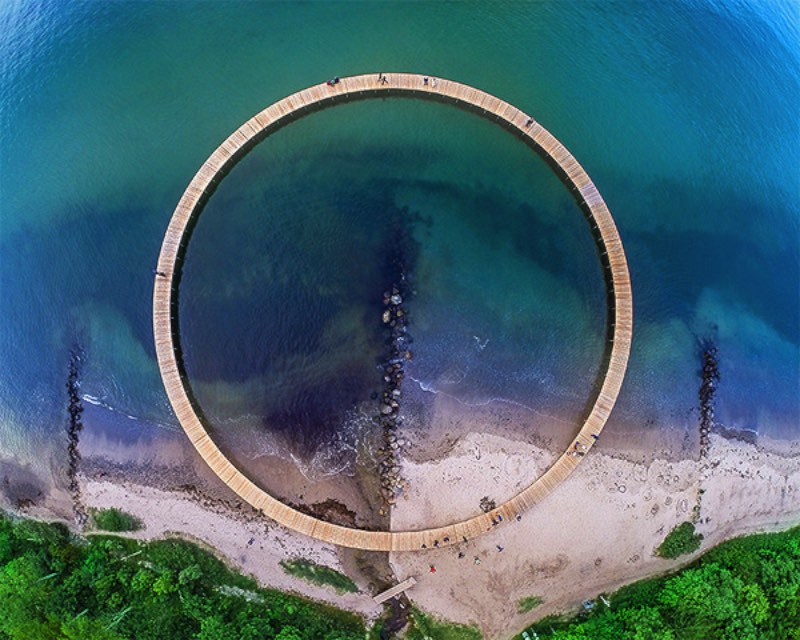 Durante o festival anual conhecido como Sculpture by The Sea, lá na Dinamarca, o escritório de arquitetura Gjøde & Povlsgaard Arkitekter criou uma ponte infinita na costa do país. A estrutura circular liga a areia da praia com o mar, voltando direto para a praia sem chegar em lugar algum.