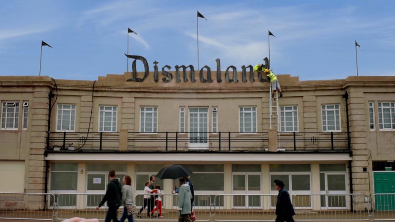 Você já viu aqui uma dezena de fotos sobre o novo projeto de arte do Banksy, o parque temático Dismaland. Mas, para deixar a experiência do parque de diversões ainda mais próximo da nossa realidade, Banksy criou essa espécie de comercial que descreve bem por que todo mundo deveria visitar o local. Além de dar um pequeno preview do que é Dismaland e as obras que podem ser vistas lá dentro.