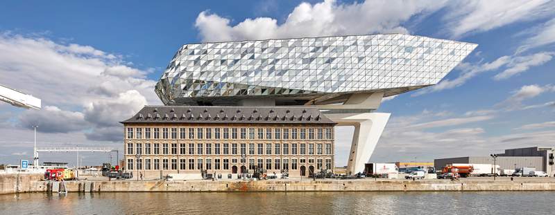 O escritório de arquitetura de Zaha Hadid acabou de inaugurar o novo Port House de Antuérpia, na Bélgica. Essa nova construção usa da estrutura base de uma antiga sede dos bombeiros na zona portuária da cidade e acabou transformando o edifício no centro para os mais de 500 funcionários que trabalhavam em prédios separados pela cidade. A construção foi feita em forma de uma extensão elevada que parece flutuar sobre o edifício original. Sua fachada é feita de vidro com a intenção de refletir as cores do céu e seu formato é inspirado nos navios que cruzam essa cidade belga todos os dias. 