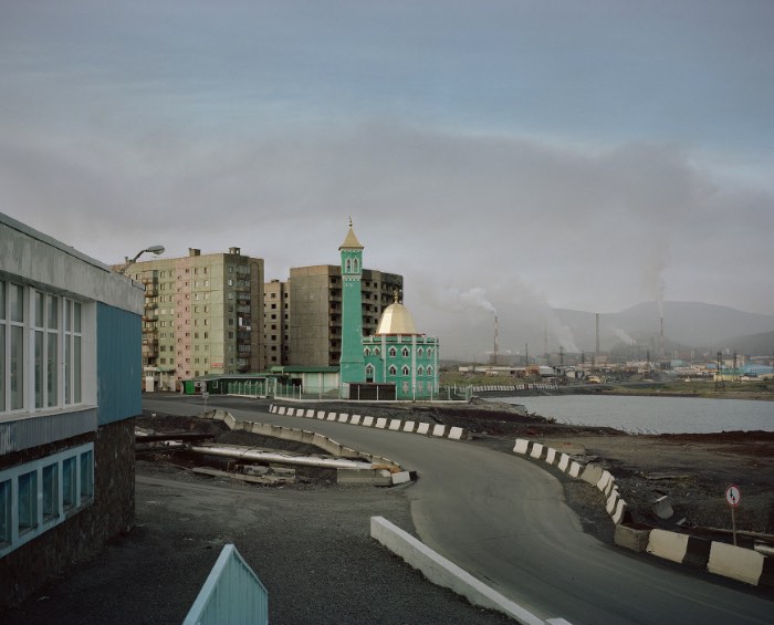 Norilsk é uma cidade russa localizada no norte da Sibéria, fazendo com que esse local seja uma das cidades mais ao norte do mundo. Mas não é só esse título que essa cidade carrega, ela também é um dos locais mais poluídos da Rússia como você vai poder ver nas fotos aqui nesse artigo. Norilsk está localizada em um dos maiores depósitos de níquel conhecidos na Terra. A cidade foi construída por prisioneiros políticos e de guerra na década da trinta, ainda na União Soviética e foi esse local que o fotógrafo Alexander Gronsky resolveu capturar com suas lentes e seus olhos. 