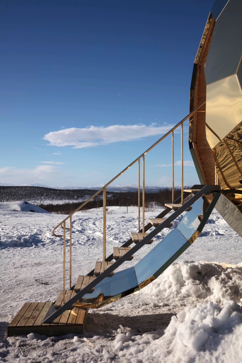 Brilhando na solidão gelada do norte da Suécia você vai encontrar uma estranha construção. Chamada de Solar Egg pelos seus criadores, a dupla conhecida como Bigert & Bergström, essa sauna feita de espelhos dourados é uma obra de arte que brilha no meio de uma paisagem repleta de neve. Essa estrutura é mais que uma sauna e mais do que apenas uma instalação excêntrica. 