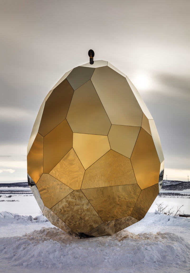 Brilhando na solidão gelada do norte da Suécia você vai encontrar uma estranha construção. Chamada de Solar Egg pelos seus criadores, a dupla conhecida como Bigert & Bergström, essa sauna feita de espelhos dourados é uma obra de arte que brilha no meio de uma paisagem repleta de neve. Essa estrutura é mais que uma sauna e mais do que apenas uma instalação excêntrica. 