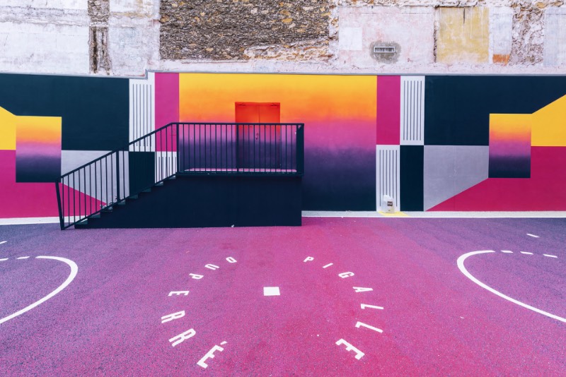 Perdida entre edifícios em Paris, você pode encontrar uma quadra de basquete que é conhecida como Pigalle Basketball Court ou algo similar mas em francês. Lá, o basquete se mistura com a arte e é tudo responsabilidade de Stéphane Ashpool que se juntou a Pigalle, a agência Ill-Studio e ao pessoal da Nike e criaram o visual ultra colorido.