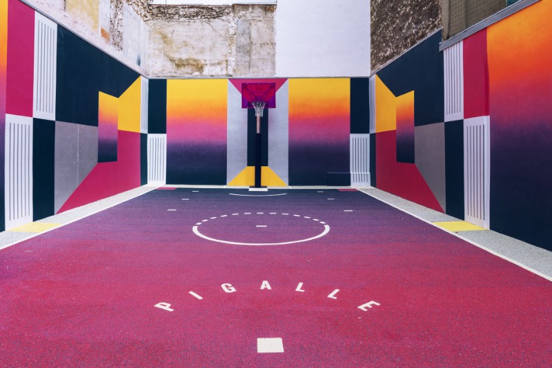 Perdida entre edifícios em Paris, você pode encontrar uma quadra de basquete que é conhecida como Pigalle Basketball Court ou algo similar mas em francês. Lá, o basquete se mistura com a arte e é tudo responsabilidade de Stéphane Ashpool que se juntou a Pigalle, a agência Ill-Studio e ao pessoal da Nike e criaram o visual ultra colorido.