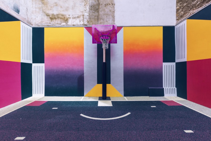 Perdida entre edifícios em Paris, você pode encontrar uma quadra de basquete que é conhecida como Pigalle Basketball Court ou algo similar mas em francês. Lá, o basquete se mistura com a arte e é tudo responsabilidade de Stéphane Ashpool que se juntou a Pigalle, a agência Ill-Studio e ao pessoal da Nike e criaram o visual ultra colorido.