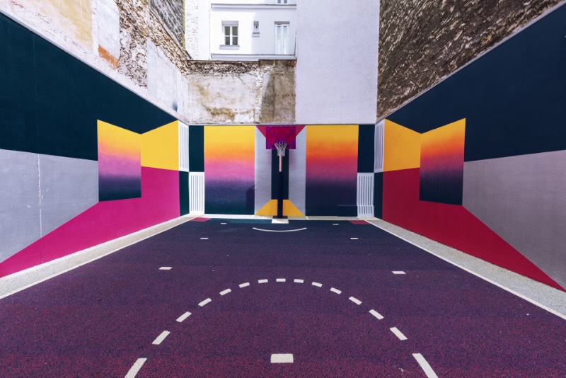 Perdida entre edifícios em Paris, você pode encontrar uma quadra de basquete que é conhecida como Pigalle Basketball Court ou algo similar mas em francês. Lá, o basquete se mistura com a arte e é tudo responsabilidade de Stéphane Ashpool que se juntou a Pigalle, a agência Ill-Studio e ao pessoal da Nike e criaram o visual ultra colorido.