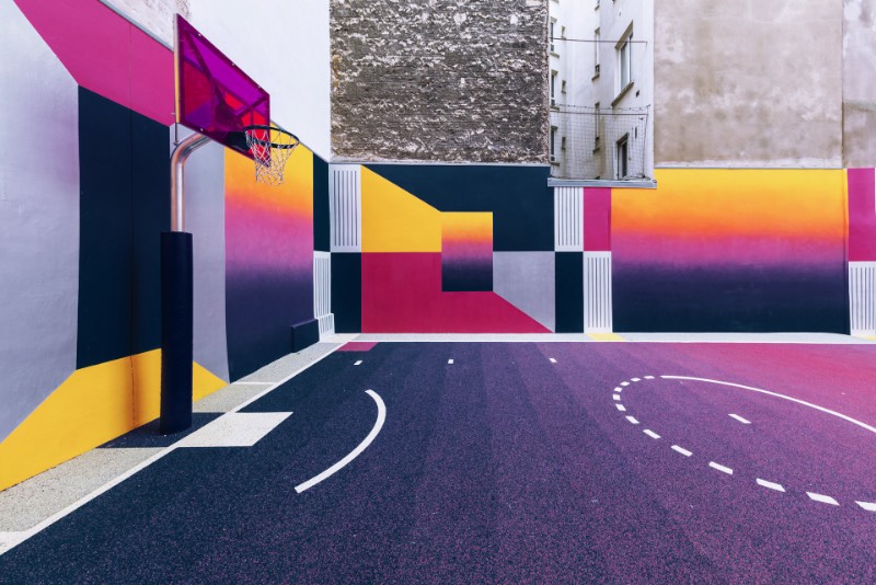 Perdida entre edifícios em Paris, você pode encontrar uma quadra de basquete que é conhecida como Pigalle Basketball Court ou algo similar mas em francês. Lá, o basquete se mistura com a arte e é tudo responsabilidade de Stéphane Ashpool que se juntou a Pigalle, a agência Ill-Studio e ao pessoal da Nike e criaram o visual ultra colorido.