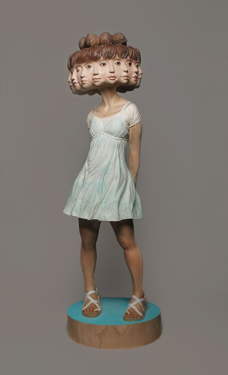 Yoshitoshi Kanemaki é um escultor japonês que abandonou a temática tradicional em direção a algo mais surreal e moderno, utilizando até de glitch em sua arte. Feitas de madeira, suas esculturas são maiores do que a realidade e desafiam as regras da anatomia, as proporções físicas e tudo aquilo que estamos acostumados de ver no corpo humano. Algumas vezes, suas esculturas aparecem com figuras faciais fora do comum, outras vezes elas se multiplicam como no caso de sua escultura de 12 faces femininas. Outras vezes, somos presenteados com olhos a mais e com cenários que mais parecem ter vindo de um sonho do que da realidade em si. Eu virei fã.