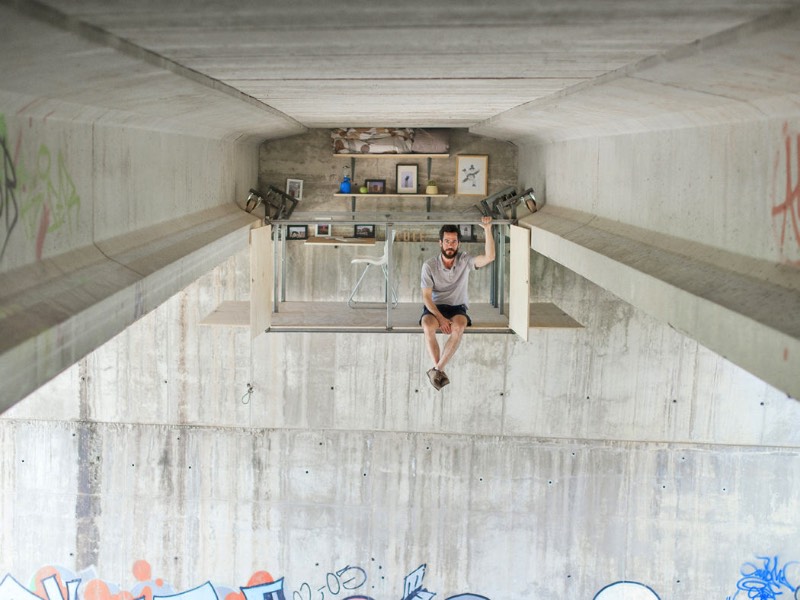 O designer espanhol Fernando Abellanas resolveu o problema de escassez de espaços para estúdios em Valencia ao criar um pop up estúdio móvel debaixo de uma ponte, no meio da cidade e acima do tráfego. O pequeno espaço que ele criou se move seguindo o vão embaixo da ponte e vem com uma prateleira, uma mesa e cadeira, de onde o designer pode trabalhar quando quiser e bem entender. 