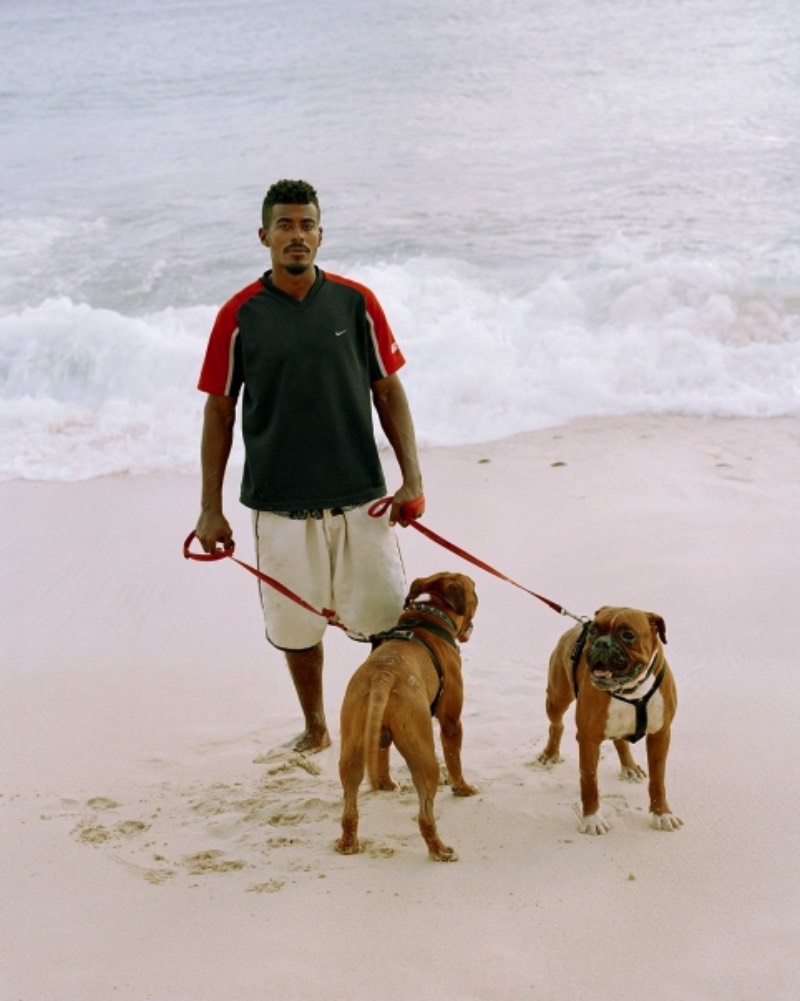 Big Papi é uma série de fotografias de Gilleam Trapenberg onde ele explora os clichês da cultura masculina e como a presença de mulheres independentes e um céu rosa deixa isso tudo de um jeito estranho em Curaçao. Essas cores foram bem aproveitadas pelo fotógrafo que resolveu usar até como temática do projeto, chamando as fotos de uma pesquisa visual na cultura da masculinidade sobreposta contra o pôr do sol da paisagem caribenha. É, Big Papi é uma série de fotos bem interessante no conceito, como que ela acabou ficando visualmente falando?
