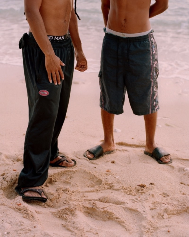Big Papi é uma série de fotografias de Gilleam Trapenberg onde ele explora os clichês da cultura masculina e como a presença de mulheres independentes e um céu rosa deixa isso tudo de um jeito estranho em Curaçao. Essas cores foram bem aproveitadas pelo fotógrafo que resolveu usar até como temática do projeto, chamando as fotos de uma pesquisa visual na cultura da masculinidade sobreposta contra o pôr do sol da paisagem caribenha. É, Big Papi é uma série de fotos bem interessante no conceito, como que ela acabou ficando visualmente falando?