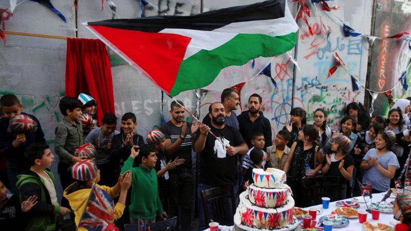 O dia 2 de novembro é um dia bem importante para os moradores da Palestina. Afinal, foi nesse dia, em 1917, que o governo Britânico divulgou um anunciado apoiado a criação de um estado para o povo judeu que acabou levando a criação de Israel. No centenário desse dia, o artista Banksy resolveu fazer uma festa pedindo desculpas pelo papel do Reino Unido em tudo que aconteceu depois da assinatura do Tratado de Balfour. O evento aconteceu na quarta feira, na frente do famosa Walled Off Hotel na cidade de Bethlehem.