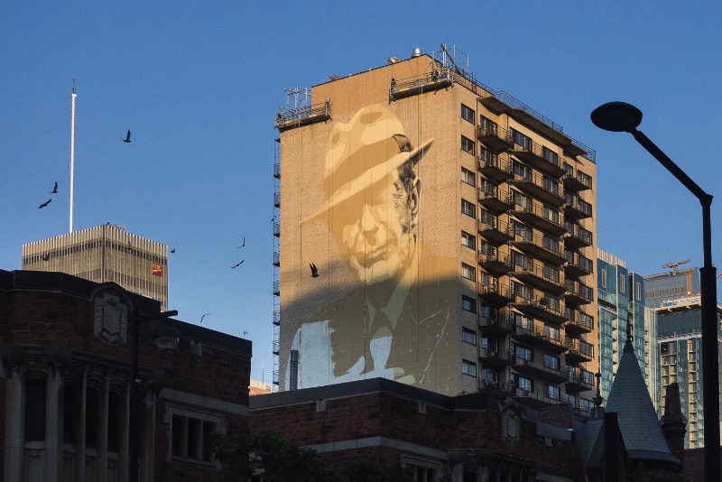 O artista conhecido como El Mac passo um tempo em Montreal, trabalhando para criar um enorme mural para Leonard Cohen em um dos muitos altos prédios da cidade. Esse mural teve a produção e assistência de MU, Gene Penson e um número grande de assistentes que conseguiram colocar em prática o centésimo mural de MU e mais um na coleção de Montreal’s Great Artists. Afinal, o projeto MU quer deixar Montreal mais bonita através de murais e parece que eles estão fazendo isso bem se você olhar as imagens que selecionei para esse artigo.