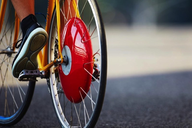 A Copenhagen Wheel é uma roda de bicicleta que vem com um objeto vermelho no centro dela. Lá dentro, você encontra um motor, uma bateria e alguns sensores que capturam a forma com a qual você pedala, incluindo ai a velocidade, o torque e sua cadência. É ai que a magia acontece.