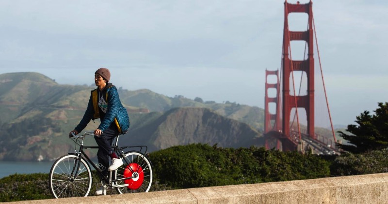 A Copenhagen Wheel é uma roda de bicicleta que vem com um objeto vermelho no centro dela. Lá dentro, você encontra um motor, uma bateria e alguns sensores que capturam a forma com a qual você pedala, incluindo ai a velocidade, o torque e sua cadência. É ai que a magia acontece.