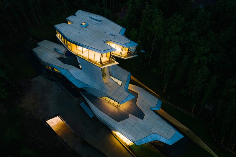 Quando me deparei com as fotografias da única residência projetada por Zaha Hadid na floresta de Barvikha, nos arredores de Moscou, sabia que ia ser obrigado a publicar essas imagens por aqui. O visual dessa residência é bem fora do comum e tem uma estética que lembra mais um filme do James Bond do que uma construção tradicional.