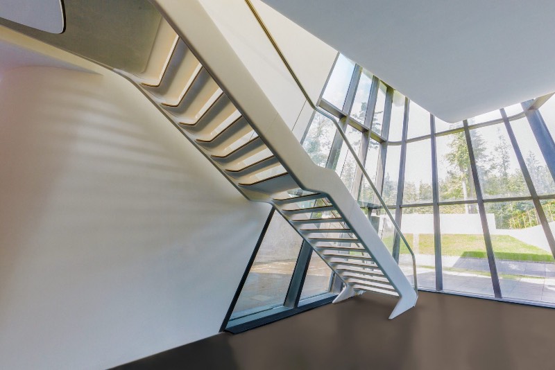 Quando me deparei com as fotografias da única residência projetada por Zaha Hadid na floresta de Barvikha, nos arredores de Moscou, sabia que ia ser obrigado a publicar essas imagens por aqui. O visual dessa residência é bem fora do comum e tem uma estética que lembra mais um filme do James Bond do que uma construção tradicional.