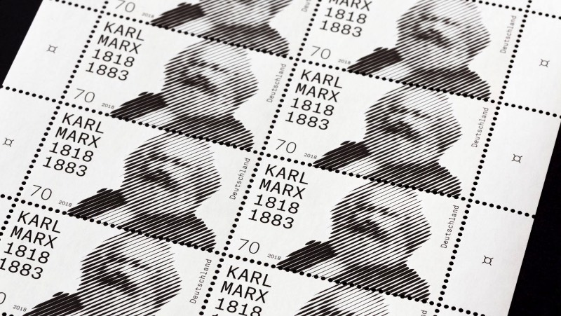 O serviço de correios da Alemanha resolveu lançar um selo celebrando os 200 anos do nascimento de Karl Marx, um dos filósofos mais importantes do país. Esse selo foi criado pelo artista visual Thomas Mayfried que ganhou uma competição aberta criada pelo Ministério Federal das Finanças da Alemanha. O selo tem uma estética abstrata e em preto e branco que foi baseada em uma icônica fotografia de Karl Marx feita em 1875 pelo fotógrafo inglês John Mayall. 