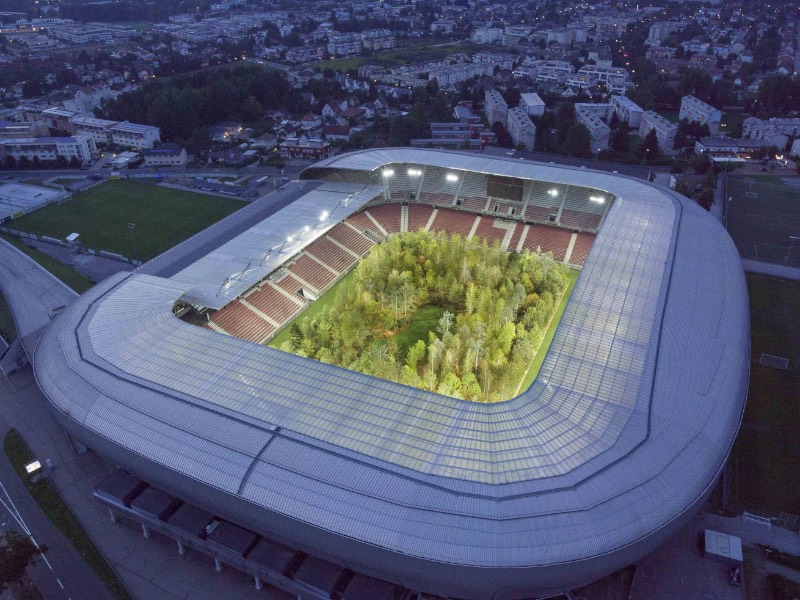 No início de Setembro de 2019, uma enorme instalação de arte foi aberta ao público na Áustria. Seu nome completo é FOR FOREST – The Unending Attraction of Nature e ela transformou o estádio de Wörthersee em uma floresta nativa da Europa Central. Algo que além de ser surreal de se ver, serve como crítica a tudo que vemos hoje quando se trata da destruição do planeta.