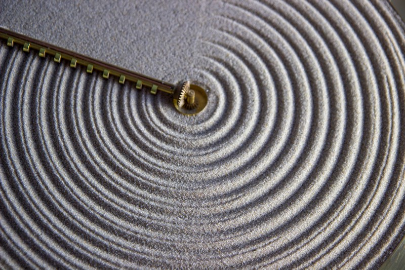 O relógio conhecido como Sand é uma celebração dos jardins de rochas japonesas, aqueles que vemos por ai em locais que tentam remeter a cultura japonesa. Conhecidos como Karesansiu, esses jardins tem a areia modelada em padrões visuais que imitam a aparência das ondulações da água. 