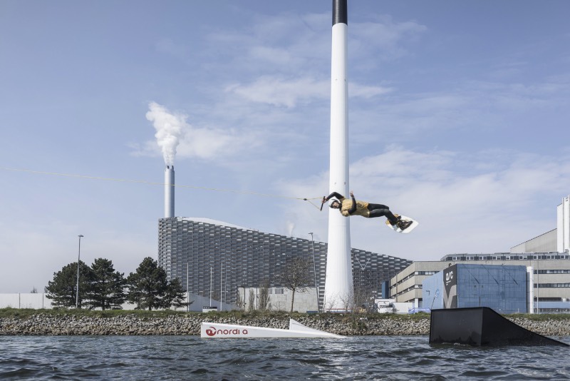 Copenhagen, a capital da Dinamarca, prometeu a seus cidadãos que seria a primeira cidade a neutralizar o carbono. Tudo isso precisa ser feito até 2025 e um dos projetos chave da cidade para colocar isso em prático é conhecido como CopenHill, criação dos designers do Bjarke Ingels Group. 