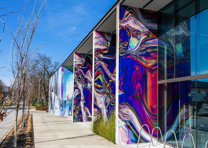 Anne Vieux é uma artista, baseada em Nova Iorque, que recentemente contribui para um projeto de intervenção urbana no centro de Bentonville, no estado americano do Arkansas. Essa instalação de arte de rua consiste em um mural quase holográfico que foi concebido pela artista de forma imersiva já que integra o projeto arquitetônico do prédio ao redor e suas paredes.