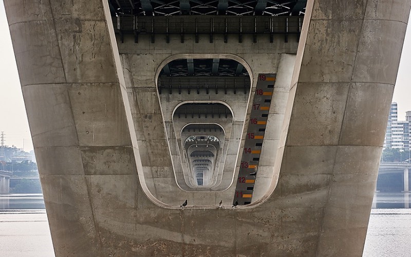 Quando você visita Seul, a capital da Coreia do Sul, você se depara com 27 pontes massivas que cruzam o rio Han. Cada uma dessas pontes de Seul tem um visual único, especial e muitos turistas gostam de fotografá-las e foi isso que Manuel Alvarez Diestro fez também. Mas ele fez isso de um ângulo um pouco menos tradicional e resolveu documentar todas essas pontes por baixo, mostrando o rio e o concreto de um jeito especial. 