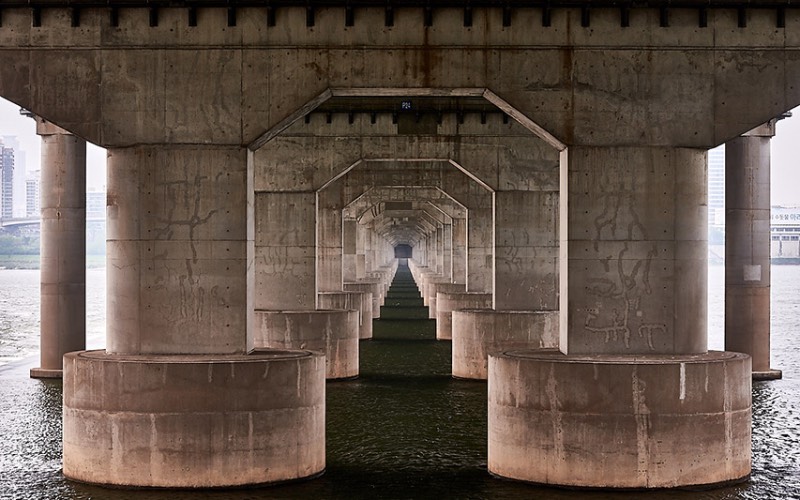 Quando você visita Seul, a capital da Coreia do Sul, você se depara com 27 pontes massivas que cruzam o rio Han. Cada uma dessas pontes de Seul tem um visual único, especial e muitos turistas gostam de fotografá-las e foi isso que Manuel Alvarez Diestro fez também. Mas ele fez isso de um ângulo um pouco menos tradicional e resolveu documentar todas essas pontes por baixo, mostrando o rio e o concreto de um jeito especial. 