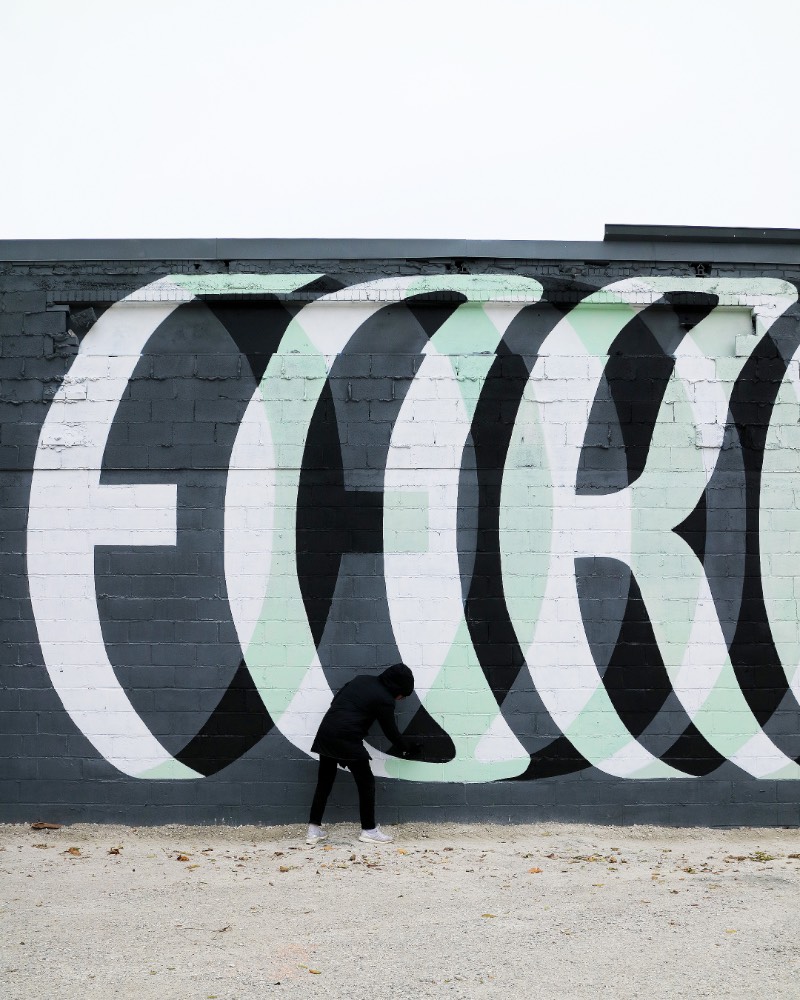 Ben Johnston é um artista cujo portfólio parece ser completamente focado em lettering e tipografia customizada para instalações, murais e arte pública. Aqui, eu resolvi explorar o que ele anda fazendo quando se trata de murais e as imagens que acabei selecionando para esse artigo são, essencialmente, nessa área de trabalho.