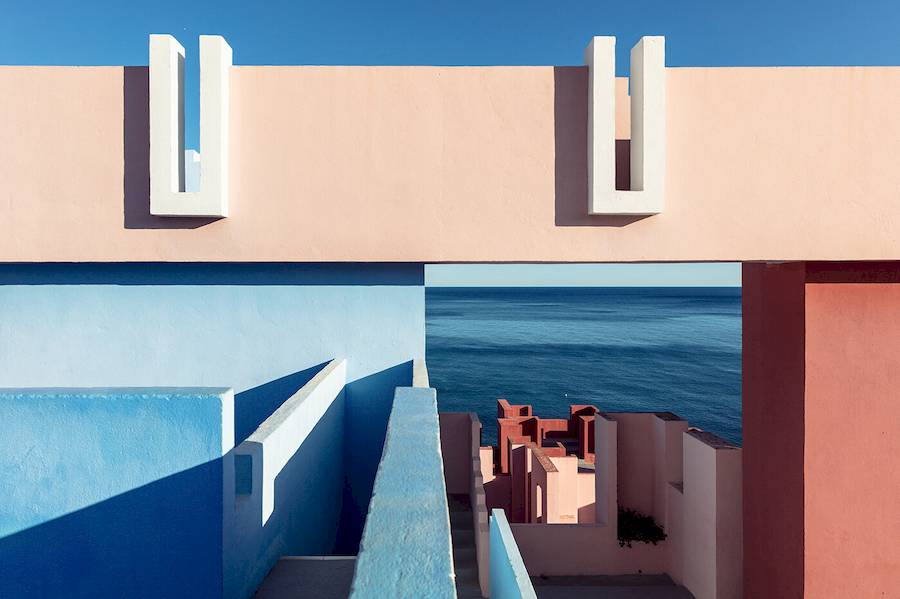 Mas, vamos falar um pouco mais sobre La Muralla Roja. Ao projetar este edifício, Ricardo Bofill inspirou-se na arquitetura das casbahs do norte da África e nos estilos árabes mediterrâneos. Ele usou dessas influências e referências e deu-lhes um toque moderno, incorporando elementos como escadas e pontes que conectam todos os apartamentos.