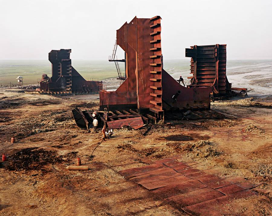 Edward Burtynsky é um renomado fotógrafo canadense conhecido por suas imagens em grande escala que capturam a sofisticada relação entre os humanos e o meio ambiente. Um dos seus projetos mais poderosos recebeu o nome de Shipbreaking, e nele o fotógrafo nos leva às costas arenosas do Bangladesh e da Índia, onde enormes petroleiros encontram o seu destino.
