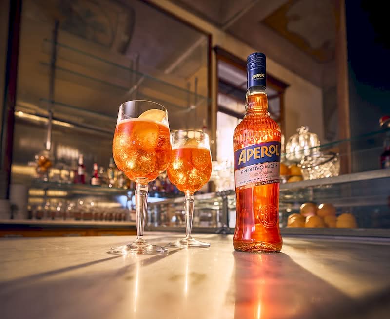 O icônico brilho alaranjado de um Aperol Spritz se tornou um símbolo quase universal do lazer, do verão e da cultura italiana do aperitivo. E mesmo as marcas mais reconhecidas do mundo precisam evoluir seu visual para se manterem relevantes no mercado. Foi por isso mesmo que o Grupo Campari anunciou no início de março o rebranding da Aperol. 