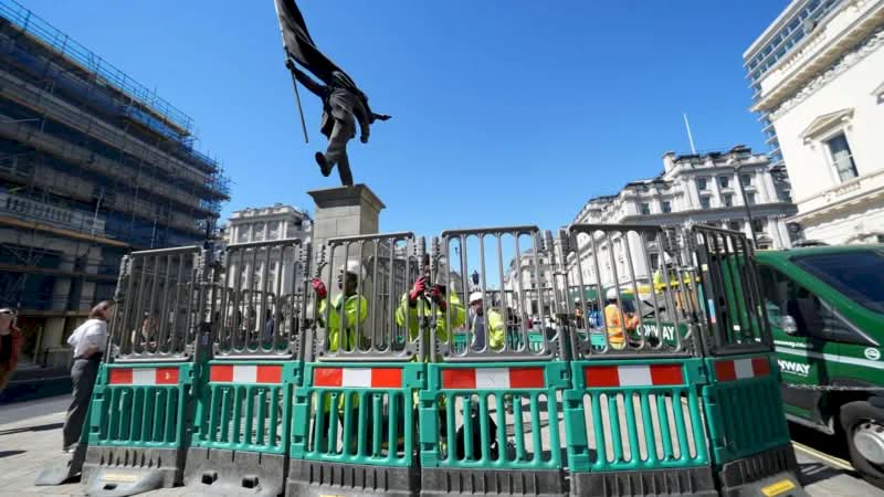 A histórica Waterloo Place, em Londres, é conhecida por seus monumentos a heróis de guerra e à realeza. Mas, no final de abril de 2026, as pessoas que passaram por essa praça foram surpreendidas com uma nova adição à paisagem urbana. Uma estátua do Banksy foi colocada em um pedestal, retratando um homem de terno, cego pela bandeira que carrega, congelado no instante em que parece estar à beira de um precipício.