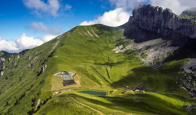O artista conhecido como Saype acabou de completar uma das suas maiores obras de arte: um homem nas montanhas da Suíça. Ocupando mais de dez mil metros quadrados, a pintura ocupa as montanhas da região de Leysin, na Suíca e foi feita através da pintura da grama no local. 