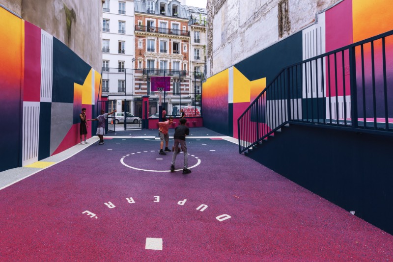Perdida entre edifícios em Paris, você pode encontrar uma quadra de basquete que é conhecida como Pigalle Basketball Court ou algo similar mas em francês. Lá, o basquete se mistura com a arte e é tudo responsabilidade de Stéphane Ashpool que se juntou a Pigalle, a agência Ill-Studio e ao pessoal da Nike e criaram o visual ultra colorido.