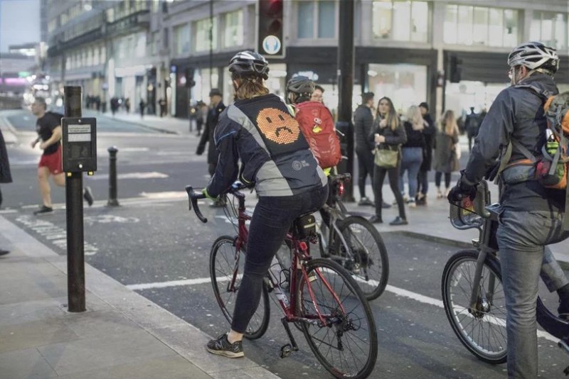 Por mais que a Ford seja conhecida pelos seus carros, essa é a empresa responsável pela Emoji Jacket com a finalidade de ajudar ciclistas a ficarem mais seguros pelas ruas das cidades. A jaqueta vem com um grande painel de led nas costas e, é lá que você apresenta seu humor e se comunica com os motoristas ao seu redor. 