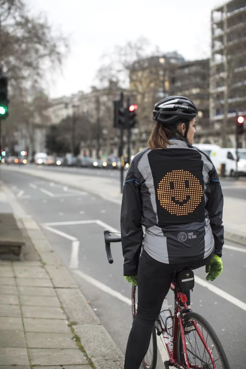Por mais que a Ford seja conhecida pelos seus carros, essa é a empresa responsável pela Emoji Jacket com a finalidade de ajudar ciclistas a ficarem mais seguros pelas ruas das cidades. A jaqueta vem com um grande painel de led nas costas e, é lá que você apresenta seu humor e se comunica com os motoristas ao seu redor. 