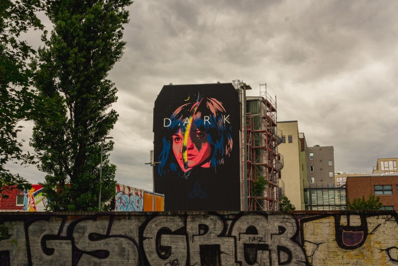 O segundo mural que fui ver fica do lado da famosa East Side Gallery e foi feito por Dale Lendl Romero. A imagem aqui mostra uma Martha dividida no meio, uma clara analogia a separação de mundos que acontece no final da segunda temporada. Visualmente falando, esse é um dos meus trabalhos favoritos já que a linha de ilustração é bem legal, as cores ficaram ótimas e eu usaria uma camiseta com esse desenho sem muitos problemas.