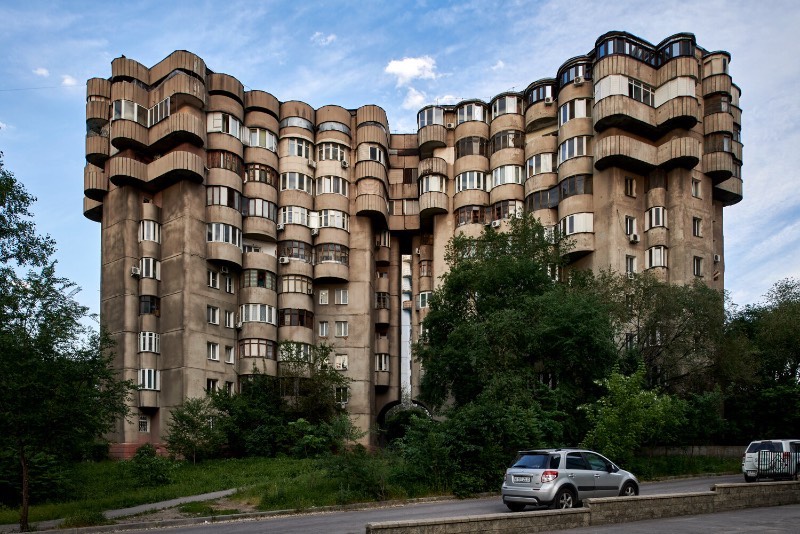 Aul Residential Complex é um edifício residencial em Almaty, no Cazaquistão. Suas formas inusitadas capturaram minha atenção quando me deparei com as fotografias que Alex Schoelcher publicou em seu Instagram há alguns meses e eu fui obrigado a pesquisar mais sobre o assunto até chegar nesse momento agora.