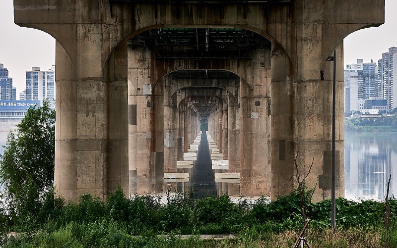 Quando você visita Seul, a capital da Coreia do Sul, você se depara com 27 pontes massivas que cruzam o rio Han. Cada uma dessas pontes de Seul tem um visual único, especial e muitos turistas gostam de fotografá-las e foi isso que Manuel Alvarez Diestro fez também. Mas ele fez isso de um ângulo um pouco menos tradicional e resolveu documentar todas essas pontes por baixo, mostrando o rio e o concreto de um jeito especial.