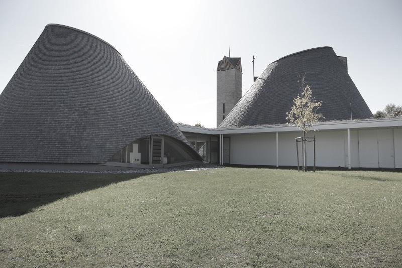 A igreja de São José de Holzkirchen foi concluída em 2016 e tem a assinatura do arquiteto alemão Eberhard Wimmer. Foi ele que projetou a estrutura cônica, feita de anéis horizontais de madeira, aço e coberto por telhas de madeira. Por dentro, o formato da igreja tem o objetivo de conduzir os olhos de seus visitantes para a luz e foi isso que chamou minha atenção nas fotografias que Birgit Schlosser tirou no local.