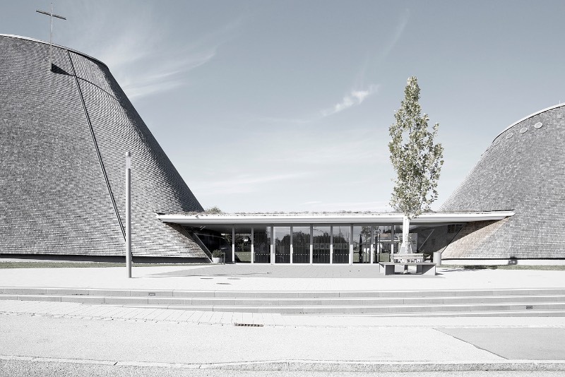 A igreja de São José de Holzkirchen foi concluída em 2016 e tem a assinatura do arquiteto alemão Eberhard Wimmer. Foi ele que projetou a estrutura cônica, feita de anéis horizontais de madeira, aço e coberto por telhas de madeira. Por dentro, o formato da igreja tem o objetivo de conduzir os olhos de seus visitantes para a luz e foi isso que chamou minha atenção nas fotografias que Birgit Schlosser tirou no local.