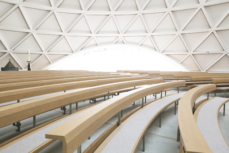 A igreja de São José de Holzkirchen foi concluída em 2016 e tem a assinatura do arquiteto alemão Eberhard Wimmer. Foi ele que projetou a estrutura cônica, feita de anéis horizontais de madeira, aço e coberto por telhas de madeira. Por dentro, o formato da igreja tem o objetivo de conduzir os olhos de seus visitantes para a luz e foi isso que chamou minha atenção nas fotografias que Birgit Schlosser tirou no local.