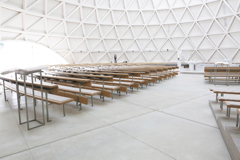 A igreja de São José de Holzkirchen foi concluída em 2016 e tem a assinatura do arquiteto alemão Eberhard Wimmer. Foi ele que projetou a estrutura cônica, feita de anéis horizontais de madeira, aço e coberto por telhas de madeira. Por dentro, o formato da igreja tem o objetivo de conduzir os olhos de seus visitantes para a luz e foi isso que chamou minha atenção nas fotografias que Birgit Schlosser tirou no local.