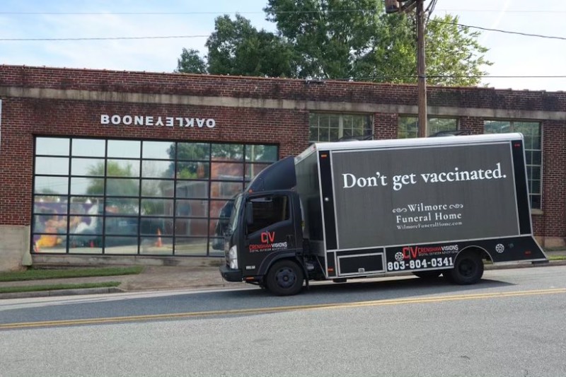 Um caminhão preto anda pelas ruas de Charlotte, na Carolina do Norte. Nele você pode ler a frase "Don't get Vaccinated" e o nome de uma agência funerária local e foi assim que a BooneOakley criou a melhor campanha a favor da vacinação que vi desde o começo da pandemia.